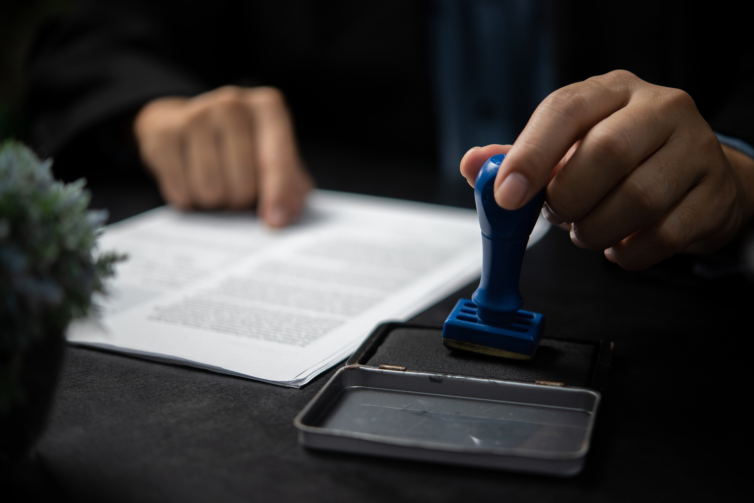 Man stamping approval of work finance banking or investment marketing documents on desk.
