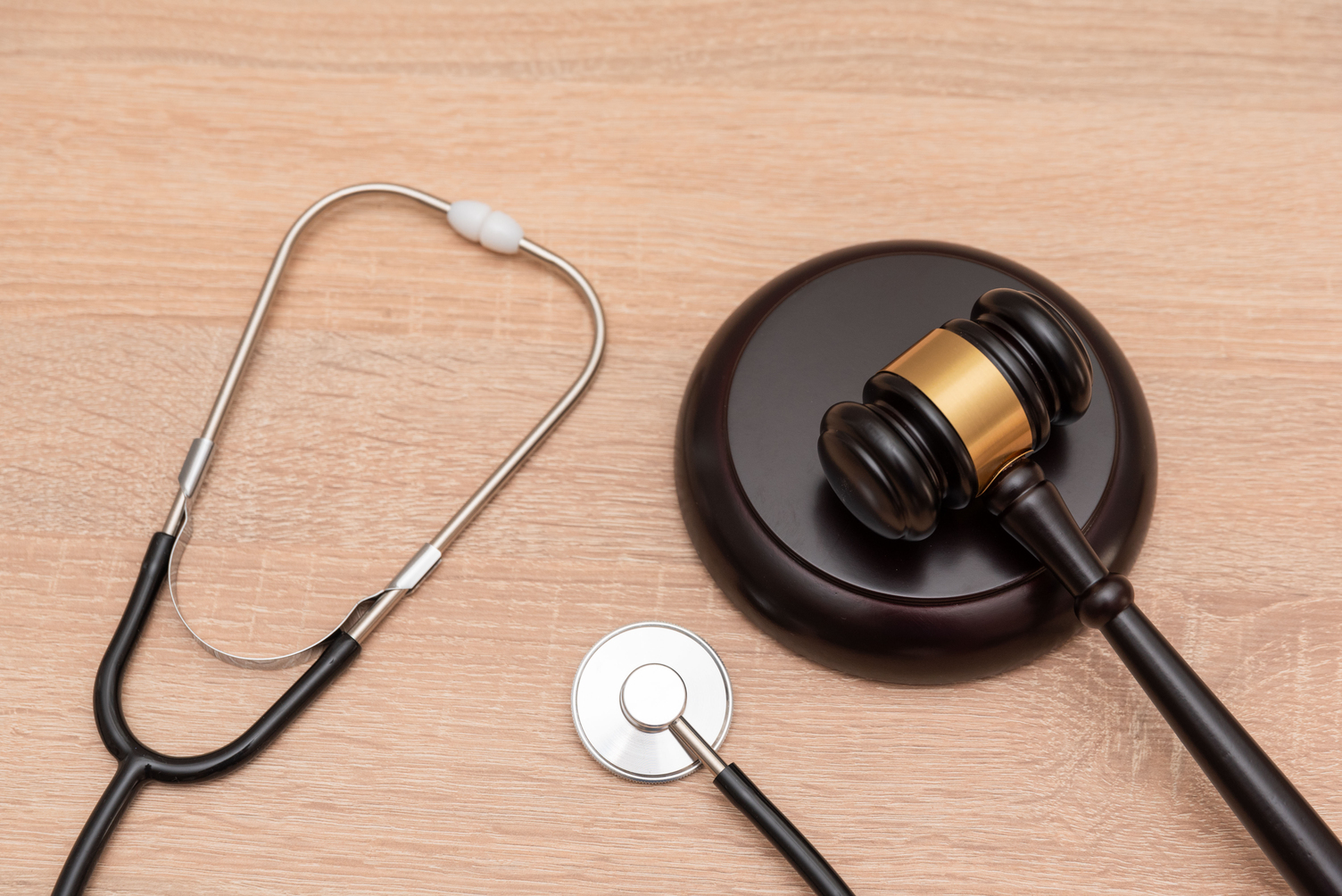 The law in medicine and healthcare concept with A gavel and stethoscope on wooden background